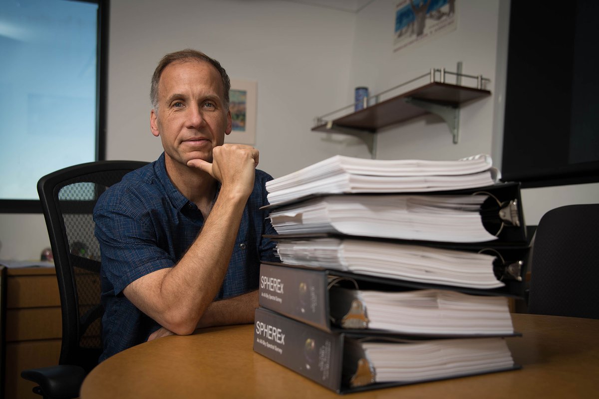 Jamie Bock and a stack of SPHEREx mission proposals.